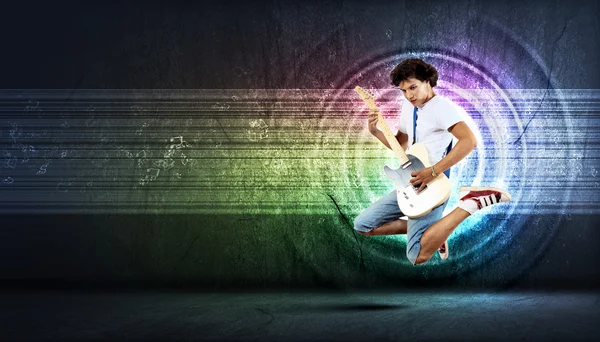 Jovem tocando guitarra electro e pulando — Fotografia de Stock