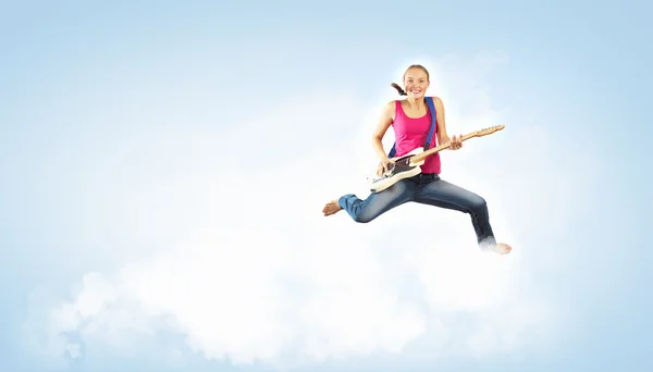 Νεαρή γυναίκα που παίζει στην κιθάρα electro και άλμα — Φωτογραφία Αρχείου