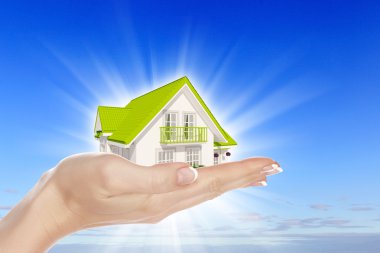 The house in hands on blue sky clipart