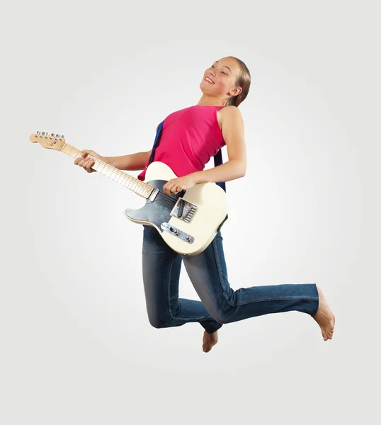 Молодая женщина играет на электрогитаре и прыгает — стоковое фото