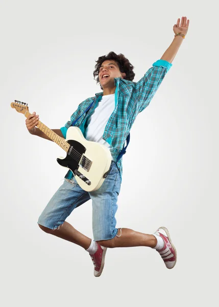 Молодий чоловік грає на електрогітарі і стрибає — стокове фото