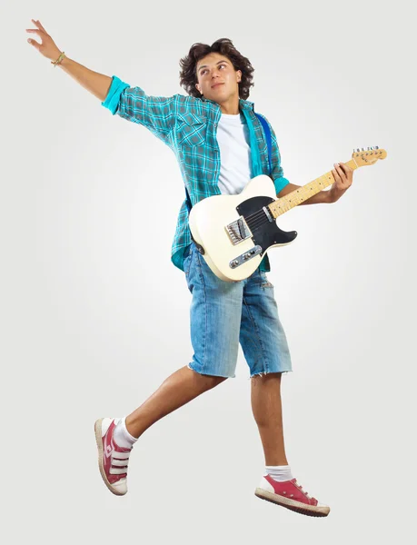 Young man playing on electro guitar and jumping — Stock Photo, Image