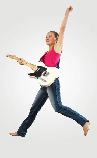 Mujer joven tocando en la guitarra eléctrica y saltando — Foto de Stock