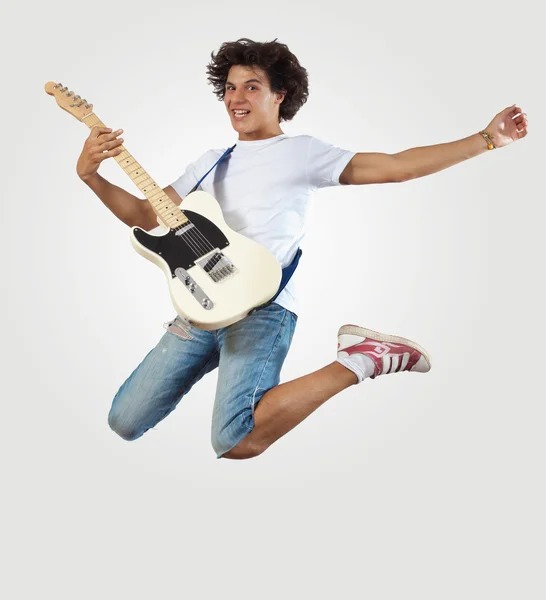 Jovem tocando guitarra electro e pulando — Fotografia de Stock