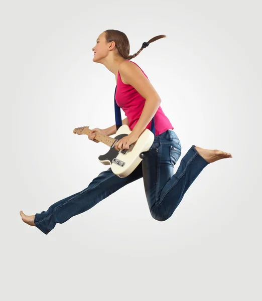 Mujer joven tocando en la guitarra eléctrica y saltando —  Fotos de Stock