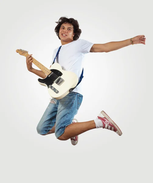 Молодий чоловік грає на електрогітарі і стрибає — стокове фото