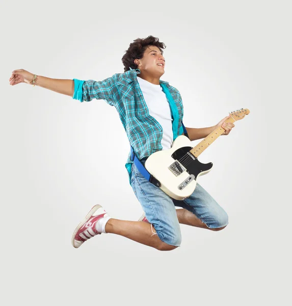 Ung man spela på electro gitarr och hoppning — Stockfoto