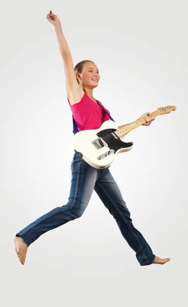 Young woman playing on electro guitar and jumping — Stock Photo, Image