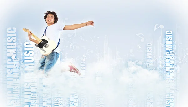 Молодой человек играет на электрогитаре и прыгает — стоковое фото