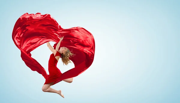 Tanzende junge Frau mit fliegendem Stoff — Stockfoto