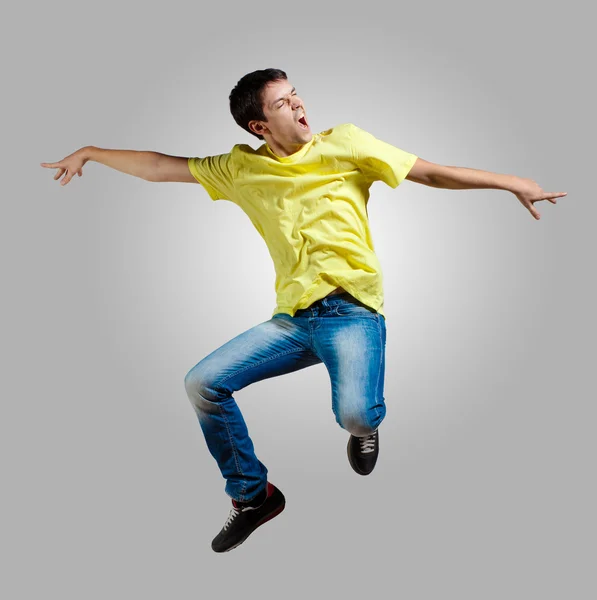 Genç adam dans ediyor ve zıplıyor — Stok fotoğraf