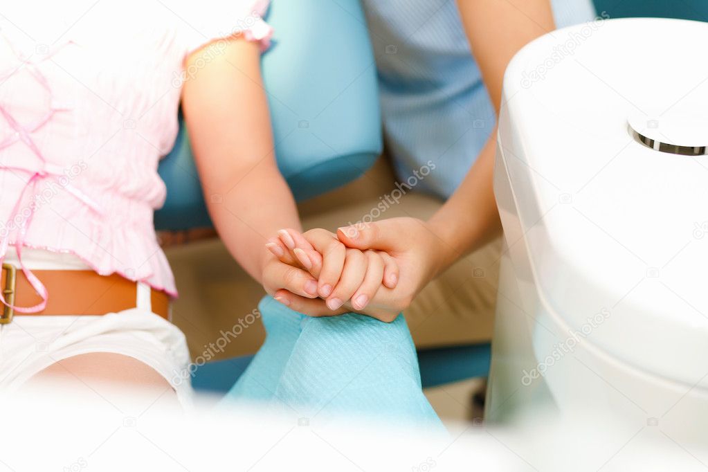 Mother and daighter holding hands visiting dentist