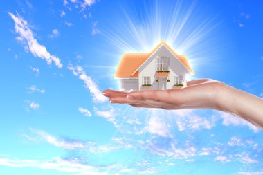 The house in hands on blue sky clipart