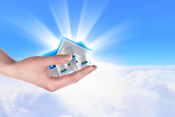 Das Haus in den Händen am blauen Himmel — Stockfoto