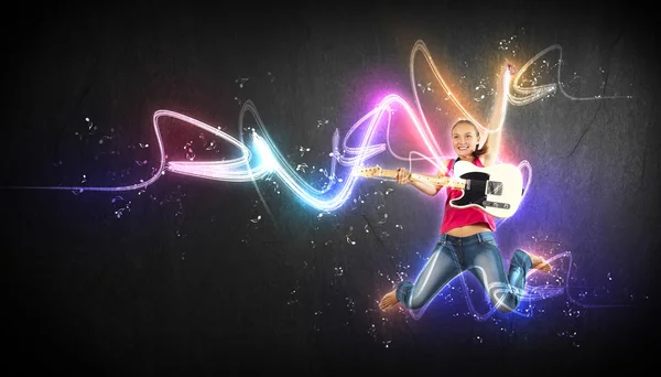 Junge Frau spielt auf Elektrogitarre und springt — Stockfoto