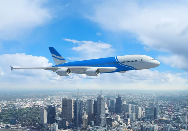 Vit passagerarplan flyger över en stad — Stockfoto