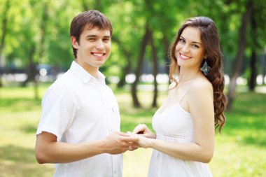 Mavi gökyüzü altında gülümseyen genç aşk Çift