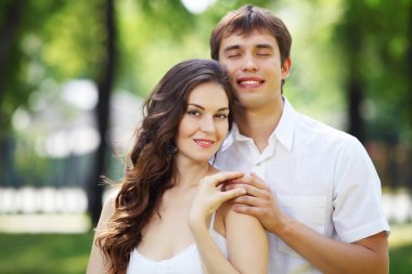 Mavi gökyüzü altında gülümseyen genç aşk Çift