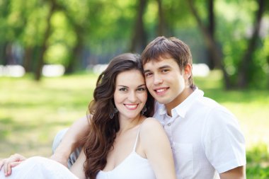 Mavi gökyüzü altında gülümseyen genç aşk Çift