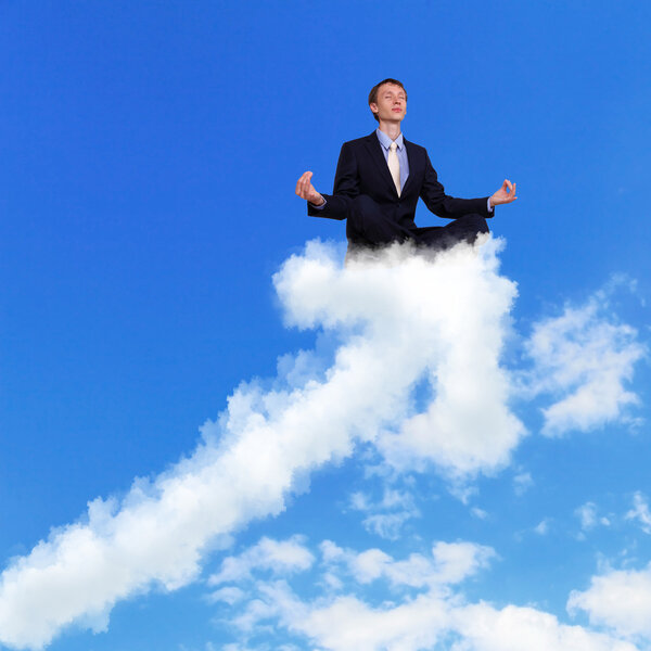 Businessman meditating sitting on the cloud