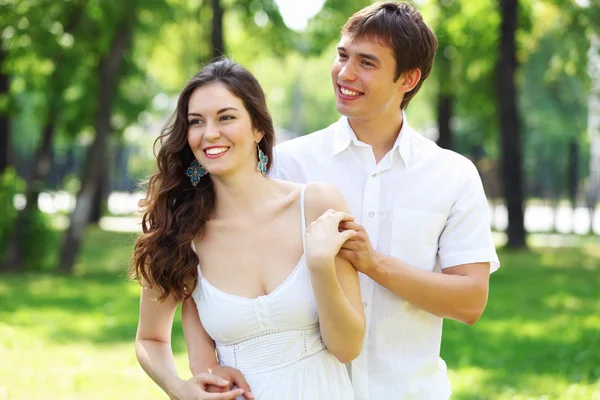年轻的爱夫妇微笑在蓝蓝的天空下 — 图库照片