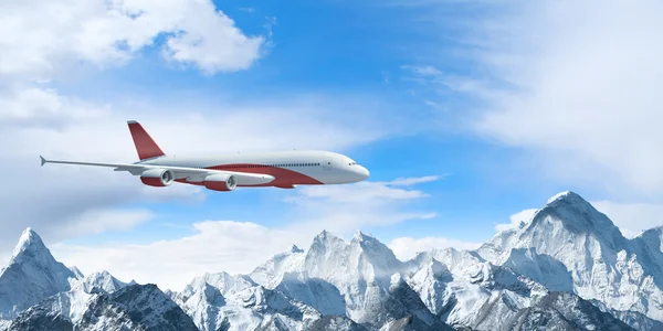 White passenger plane above the mountains — Stock Photo, Image