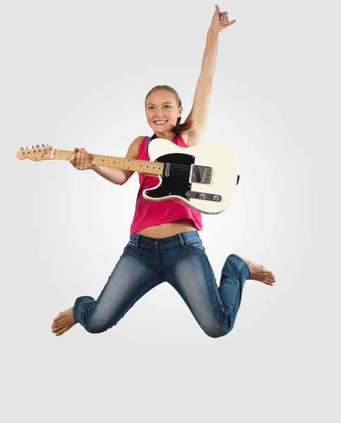 Junge Frau spielt auf Elektrogitarre und springt — Stockfoto