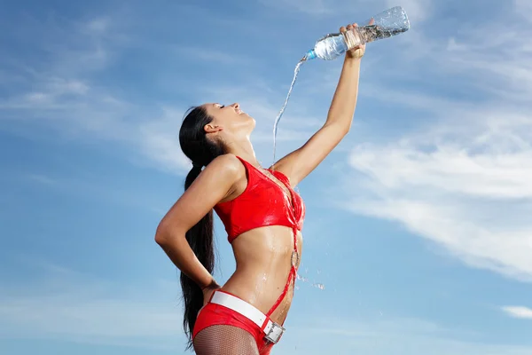 Junge Sportlerin mit einer Flasche Wasser — Stockfoto