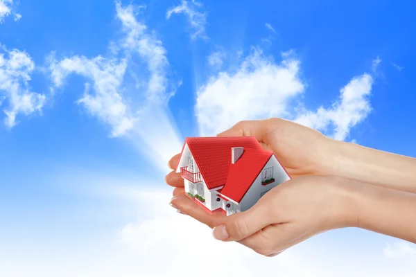 La casa en las manos en el cielo azul — Foto de Stock