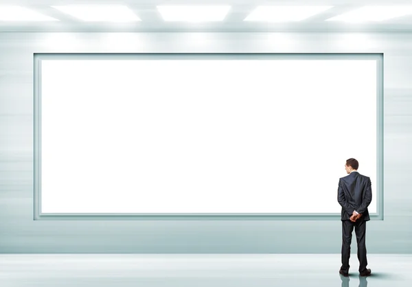 Geschäftsmann steht in der Nähe einer leeren Plakatwand — Stockfoto