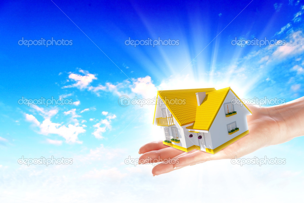 The house in hands on blue sky