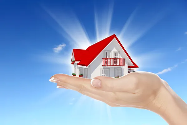 Het huis in handen op blauwe hemel — Stockfoto