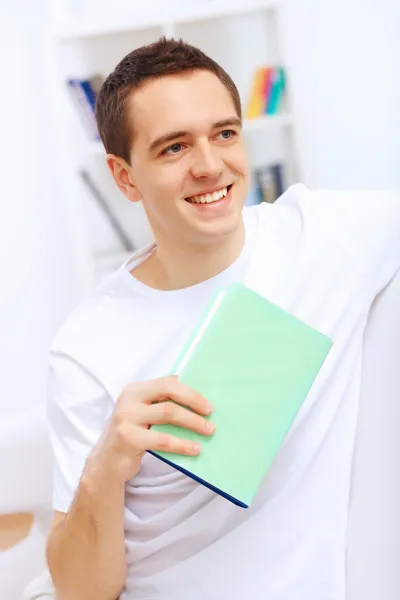 Jovem em casa com um livro — Fotografia de Stock