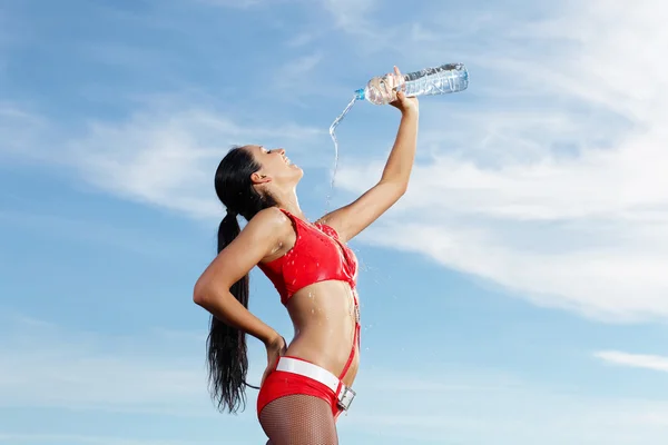 Junge Sportlerin mit einer Flasche Wasser — Stockfoto