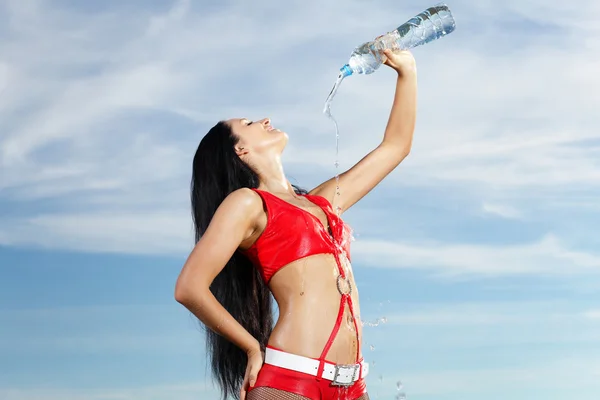 Junge Sportlerin mit einer Flasche Wasser — Stockfoto