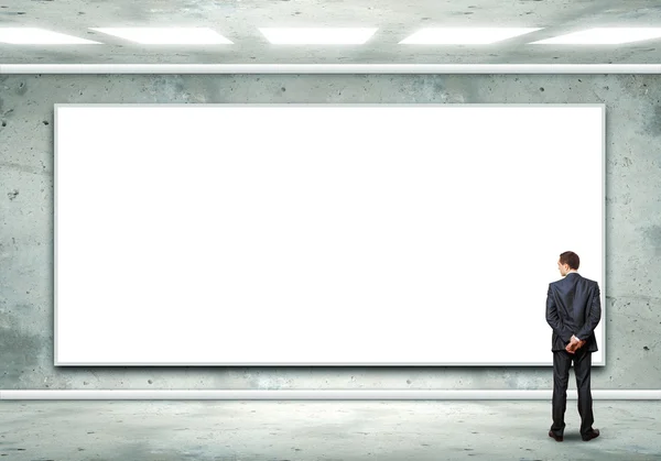 Geschäftsmann steht in der Nähe einer leeren Plakatwand — Stockfoto