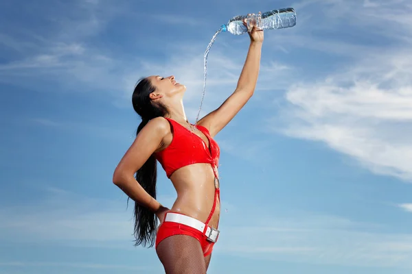 Junge Sportlerin mit einer Flasche Wasser — Stockfoto