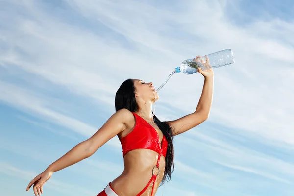 Junge Sportlerin mit einer Flasche Wasser — Stockfoto