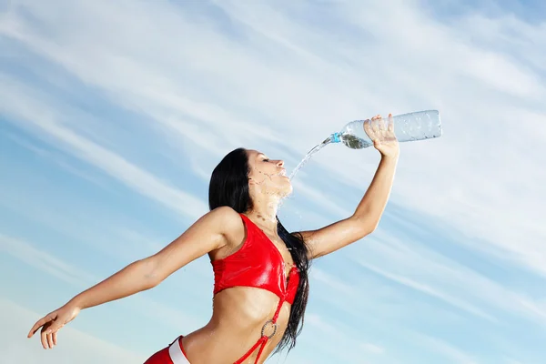 Junge Sportlerin mit einer Flasche Wasser — Stockfoto