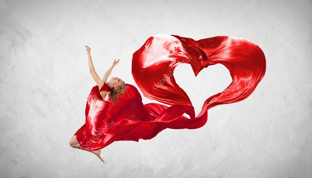 Dancing young woman with flying fabric
