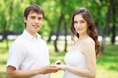 Mavi gökyüzü altında gülümseyen genç aşk Çift