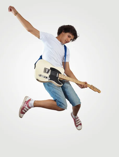 Young man playing on electro guitar and jumping — Stock Photo, Image