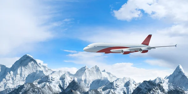 White passenger plane above the mountains — Stock Photo, Image