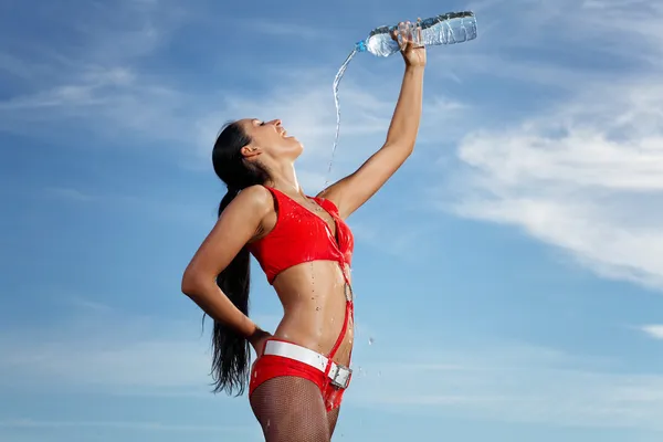 Junge Sportlerin mit einer Flasche Wasser — Stockfoto