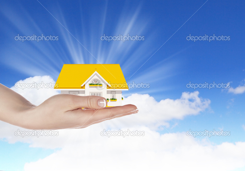 The house in hands on blue sky