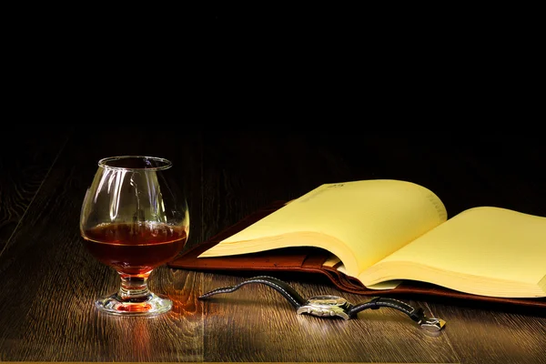 Cognac, cigarr och en gammal bok i närheten — Stockfoto