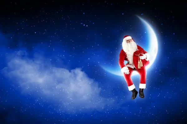 Foto de Papai Noel sentado na lua — Fotografia de Stock