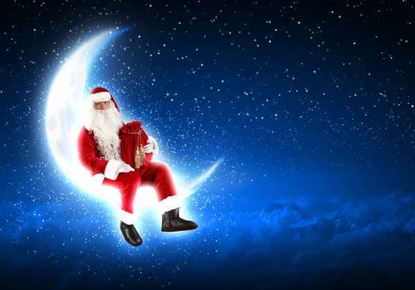 Foto de Papai Noel sentado na lua — Fotografia de Stock