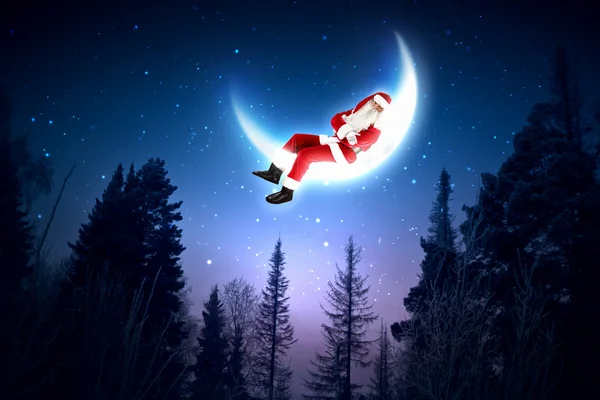 Фото Санта-Клауса, сидящего на Луне — стоковое фото