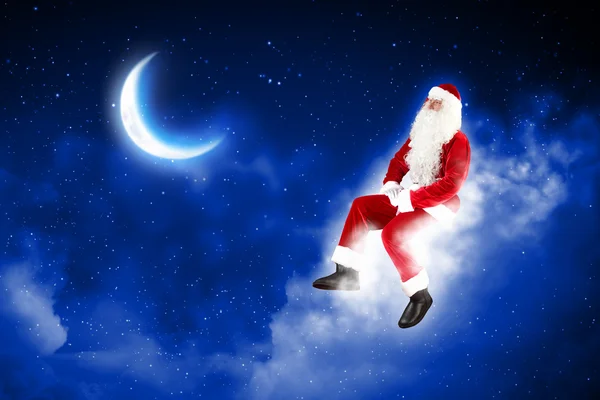 Foto de Papai Noel sentado na lua — Fotografia de Stock